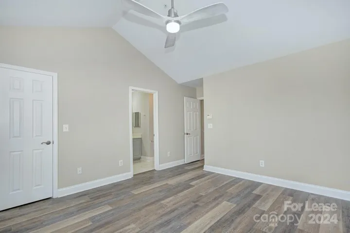 Primary bedroom with LVP flooring and custom ceiling fan