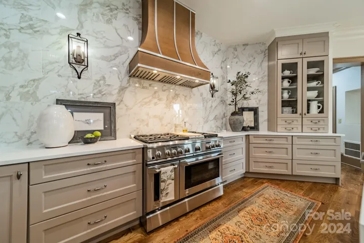 Custom range hood, high end gas range and gorgeous backsplash wall