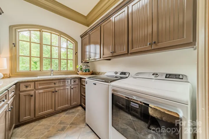 The Laundry Room features custom cabinetry, utility sink and a home management space via the builtin desk.