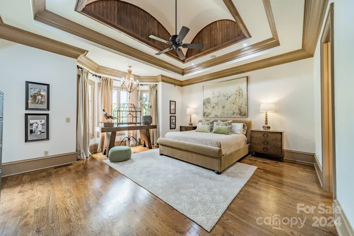 The Expansive Main Level Primary Bedroom features a bay window overlooking the pool and cabana.  This sophisticated and serene space is enhanced by the architectural elements   and the rich hardwoods.