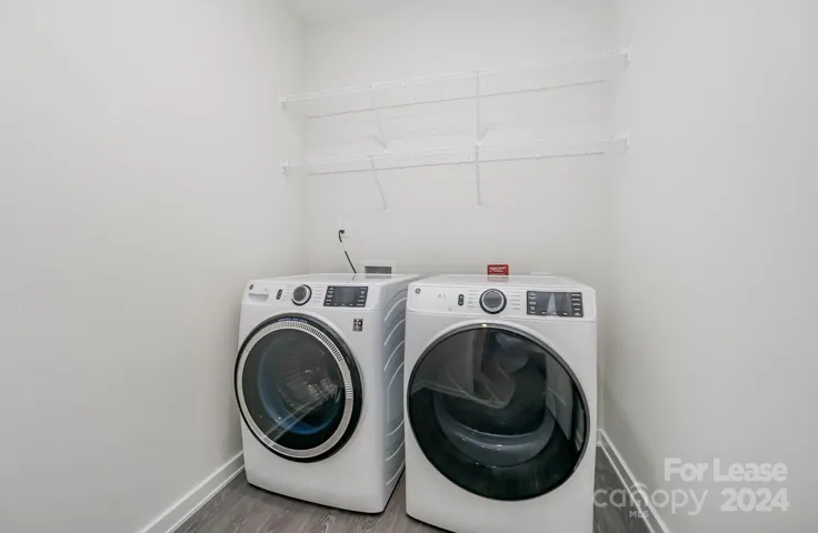 Laundry room has washer, dryer, and wire shelving!