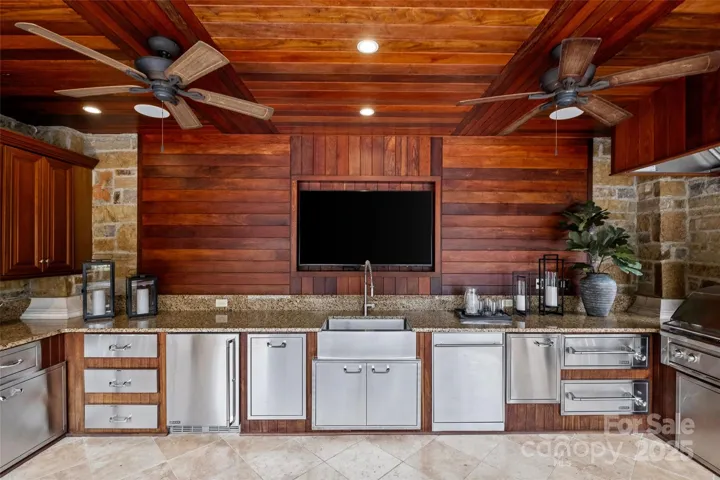 Cabana with outdoor Kitchen and entertainment center with custom cabinetry and Lynx appliances.Ice machine, 50” built-in gas grill and sauté station with hood systemwarming drawer, dishwasher, beverage refrigerator.