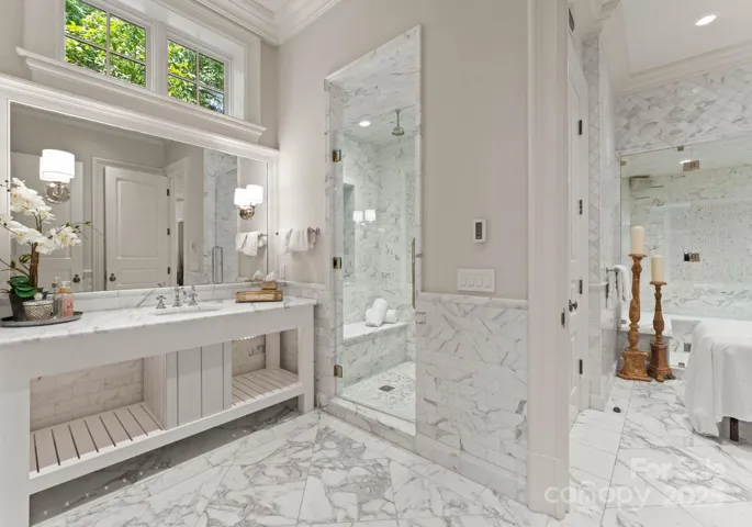 Full bathroom with rain head shower, and marble floors.