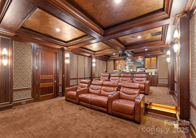 Stadium seating with eight luxury leather reclining chairs, bar top, prep, and additional cabinetry with antique mirror backsplash.