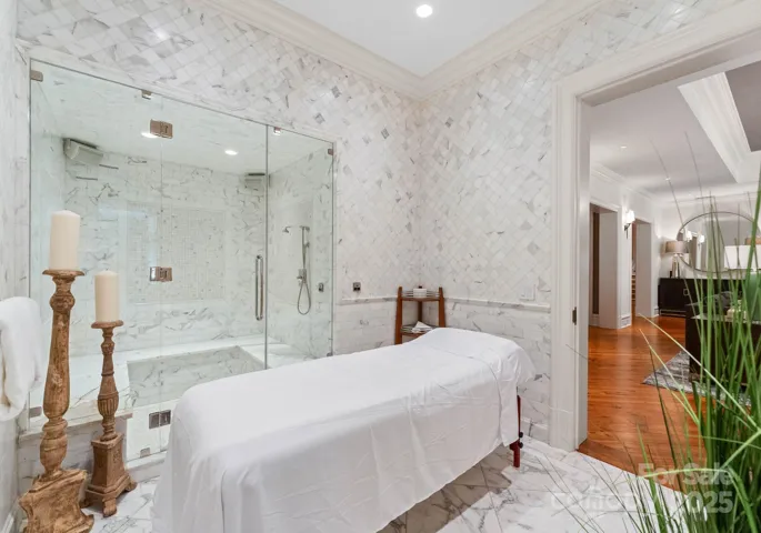 Spa with 6 person steam shower. Floor to ceiling marble tile.