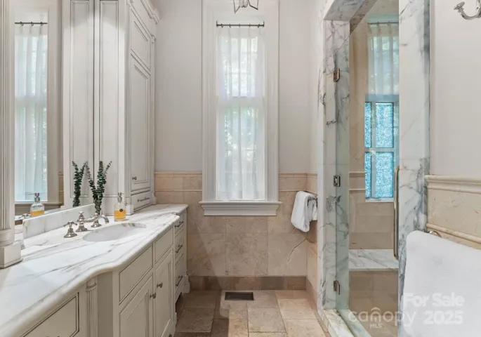 Primary bathroom includes separate spacious water closets with bidet, walk-in shower with Waterworks fixtures. Ceiling accent lighting.