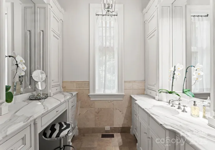 Primary bathroom is a spa-like oasis. Individual vanities, make-up station, oversized soaking tub and heated travertine tile floors. Floor to ceiling mirror