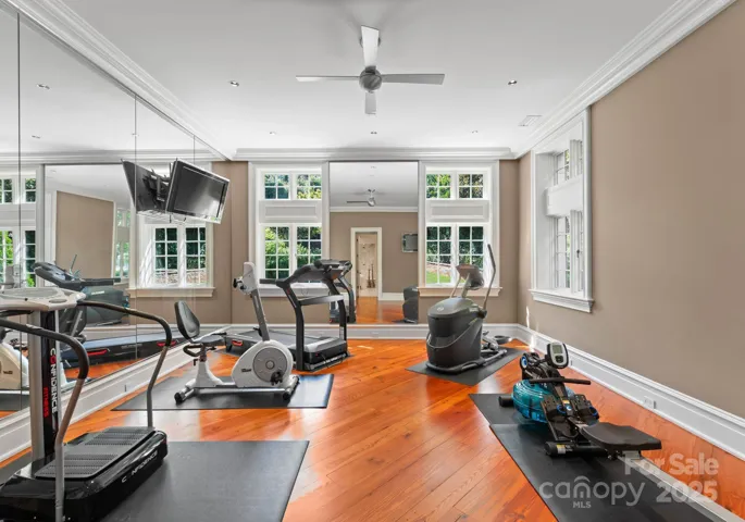 Fitness/Yoga Studio/6th bedroom. Floor to ceiling mirrors, ceiling fan, and TV’s.