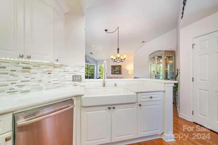White kitchen with stainless appliances and farm sink. Lovely neutral color palette draws allows you to focus on the views out the windows