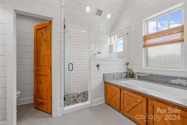 Gorgeous primary bath with tile shower, jetted soaking tub, soaring ceiling.