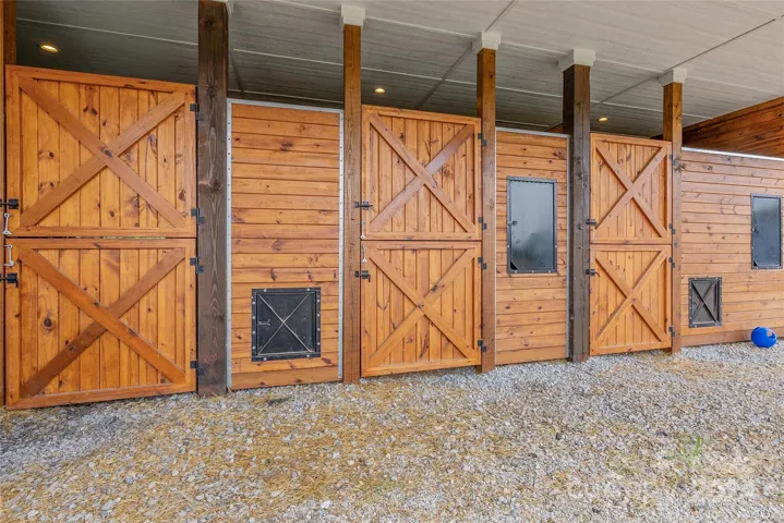 Three 12'x12' stalls with custom fronts and pull outs for hay and water. Hot and cold wash rack. Tack Room.
