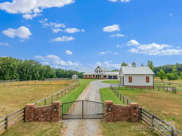 Property has full perimeter fencing, 4 board fence along road frontage, and an automatic gate.