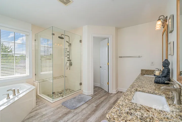 Updated Primary en suite bath with double vanities, step in shower and garden tub.