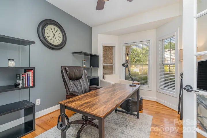 Private office on the main level with glass French doors and bay window.