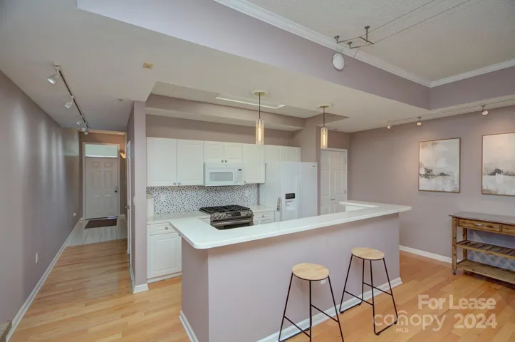 Updated Kitchen with quartz countertops, tile backsplash, gas range, island and pantry!