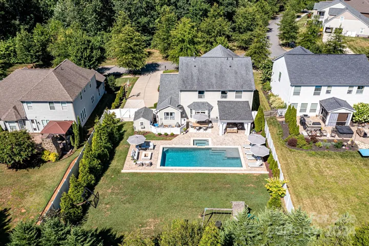Aerial View of Gorgeous Outdoor Living Area with coveted, Salt Water Pool/Spa, fire pit area, covered back porch & plenty of decking for seating/lounging!