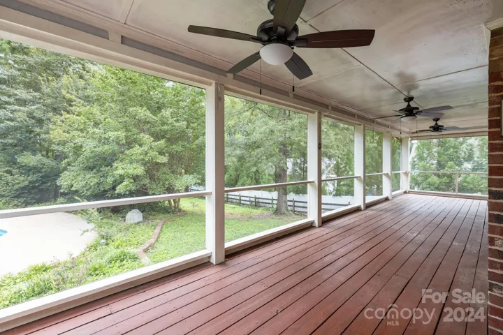 Expasive screened in porch overlooks the 1.3 acre lot and pool deck.