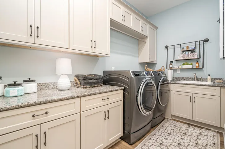 Large Laundry room on the main floor with plenty of counter space, hanging space and a sink. Tucked just off the rear hall, it is convenient but removed from the social spaces