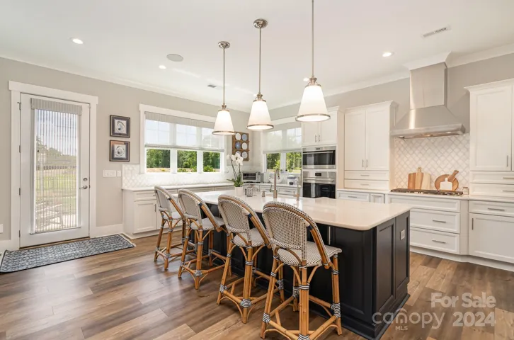 Super sized island is the perfect gathering spot with light streaming through the windows