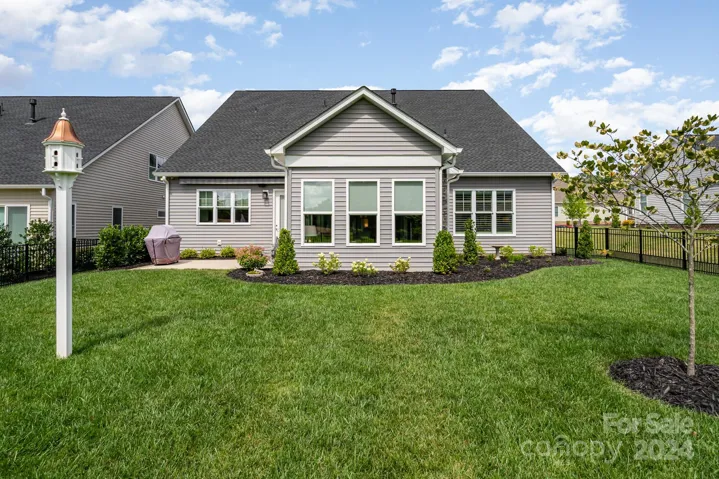 The yard is fully fenced and overlooks an HOA space. Enjoy evening out grilling under the custom awning