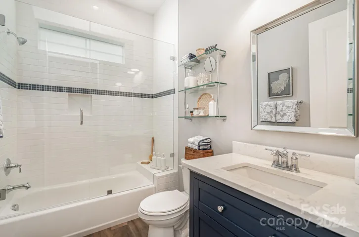 Shared bath serves the two bedrooms. Featuring specialty glass, custom tile and custom vanities.