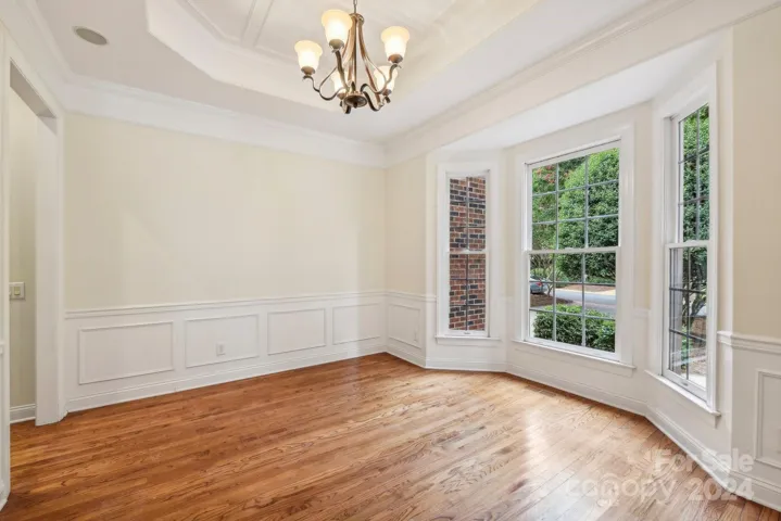 Pretty bay window, picture moldings and tray ceiling in formal dining room.