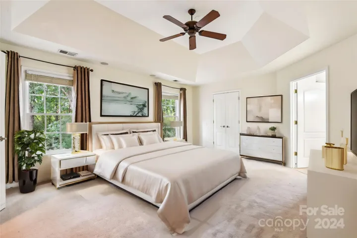 Generously sized primary has tray ceiling and overlooks wooded yard. Virtually staged.