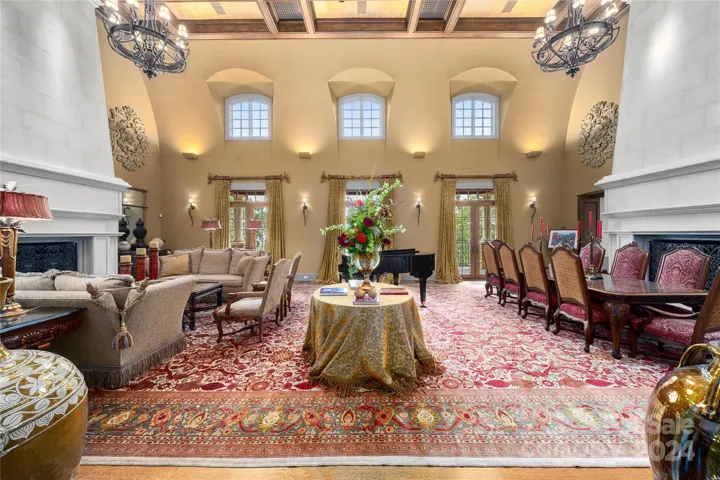 Formal Living Room and Formal Dining Room with two 35 foot oversized Italian limestone fireplaces on each side,  with grand piano. 35 Foot coffered ceiling. French doors go out to balcony with views of the Blue Ridge Mountains.