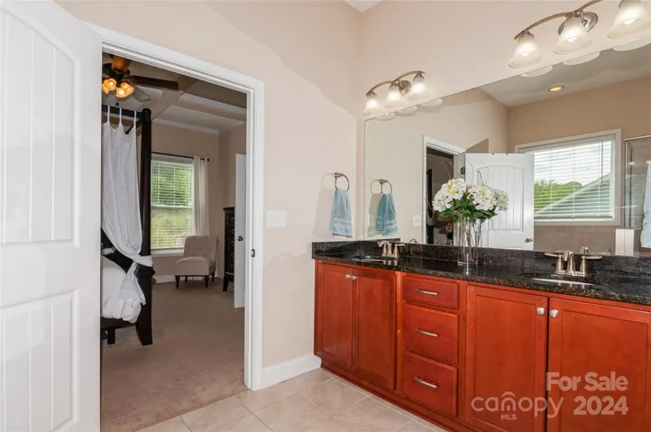 Primary Bathroom with dual sinks and granite countertops