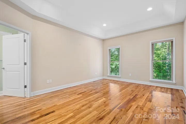 Main Bedroom with recess lighting deep dish ceiling Hardwood floors, full length windows.