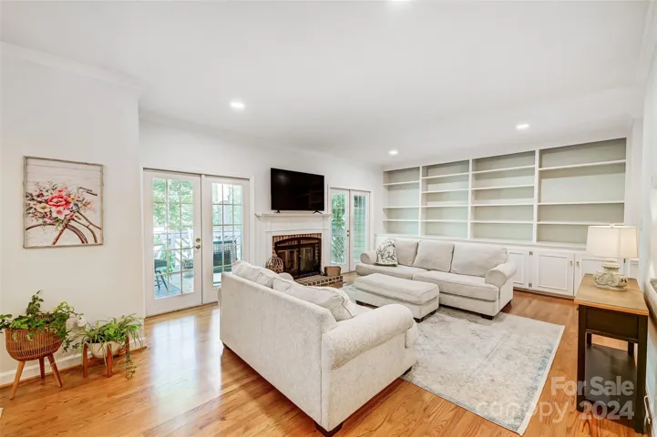Great room boasts built-in cabinetry, cozy fireplace, and access to balcony
