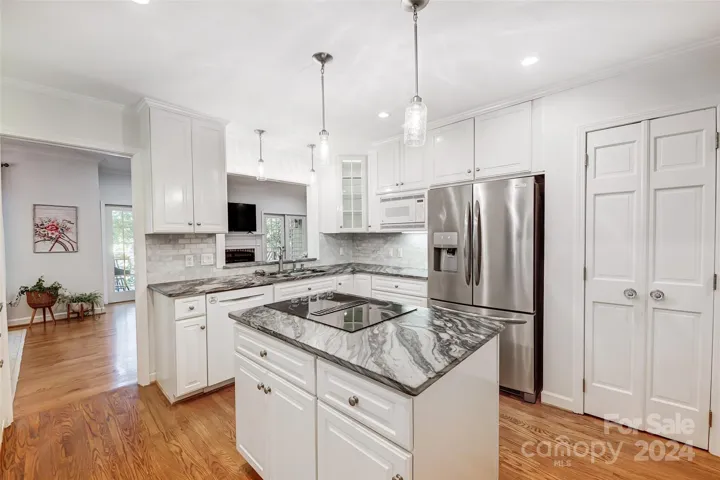 Lovely chef's kitchen equipped with ss appliances, double ovens, leathered quartzite counter center island, quartzite counters, plenty storage, & pantry