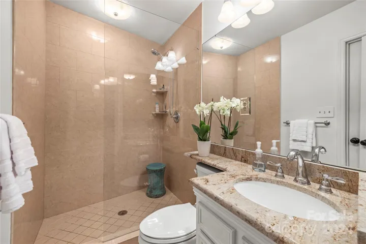 Bathroom 3 features a tile shower and vanity with granite counter tops