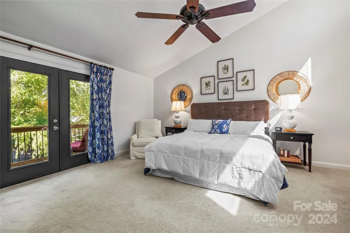 The roomy primary bedroom features a vaulted ceiling and has amazing lake views
