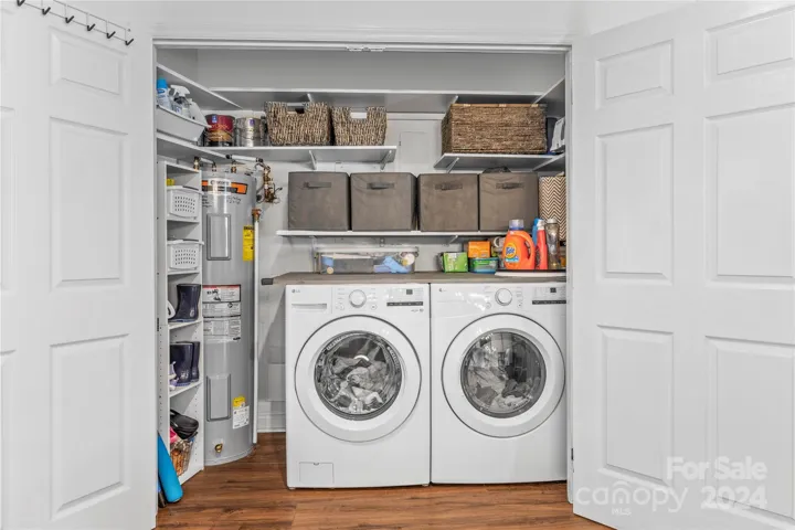 The laundry room is conveniently located off of the kitchen and features built in shelving for storage