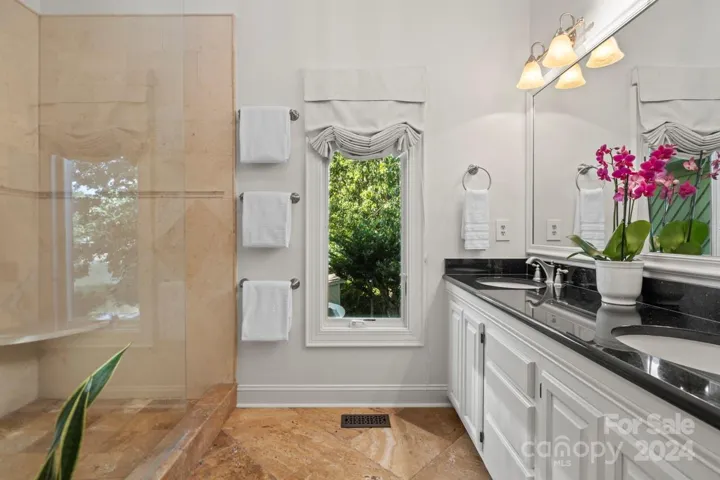 The ensuite primary bathroom on the upper level features tile flooring