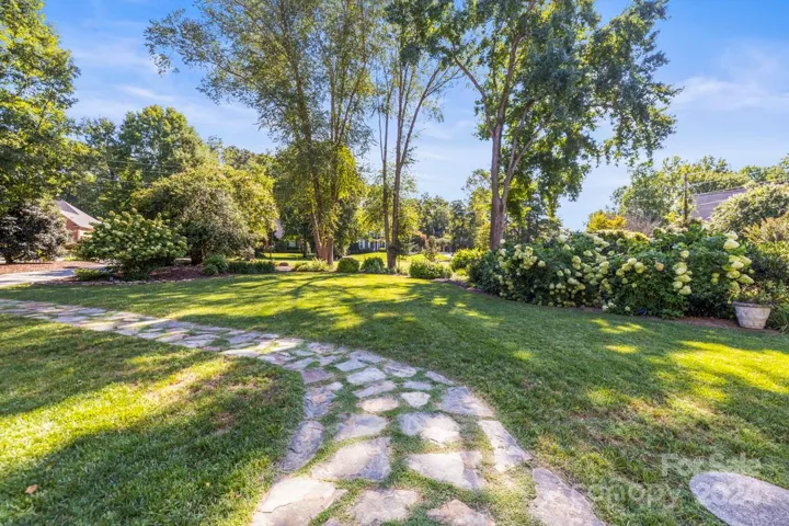 The front yard features lush garden areas