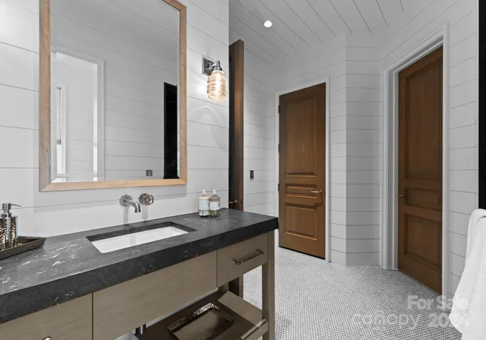 The poolside bath is equipped with a walk-in shower, water closet, storage closet, and a drop zone from the pool.