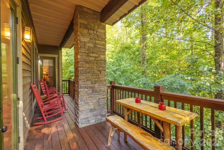 Large full length porch overlooks forest below