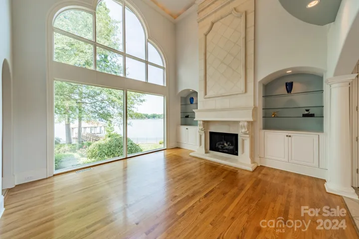 Living room has a picturesque view of the lake, floor to ceiling fireplace and 20' cathedral ceilings