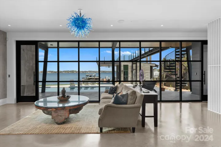 Lake-level recreation room with a wall of windows overlooking the pool deck and the lake beyond.
