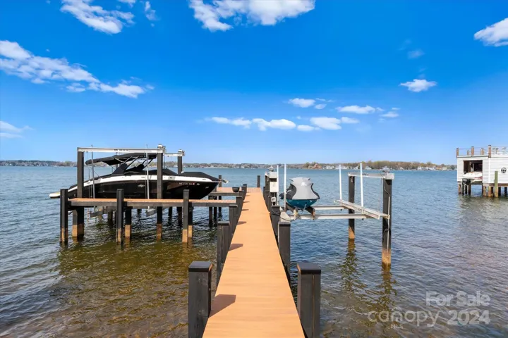 Private dock featuring engineered decking, dual boat lifts, a PWC lift, and sunbathing deck.