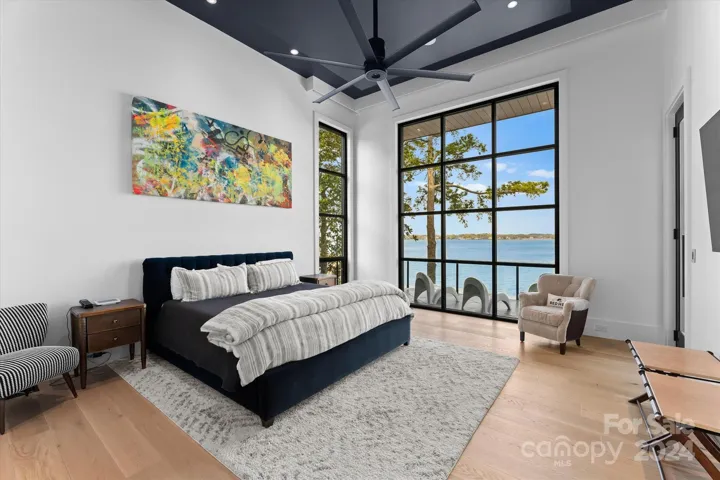 The primary bedroom features 12-foot industrial windows, offering an endless expanse of glass that frames uninterrupted views and floods the space with natural light.