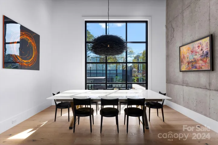 The dining area is bathed in natural light from soaring windows.