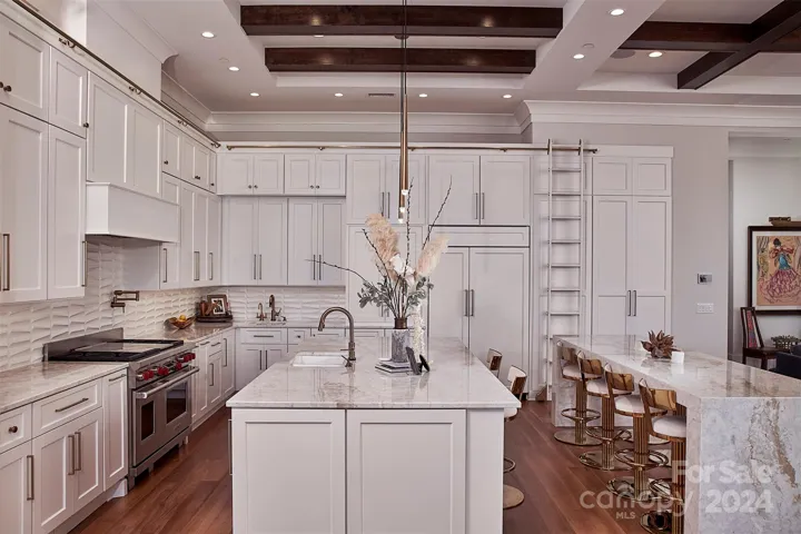 Custom kitchen is a chef's dream!  Abundant storage, cabinets built to 10' high accessed with rolling ladder.  Quartzite counters & waterfall island that seats 8-10.