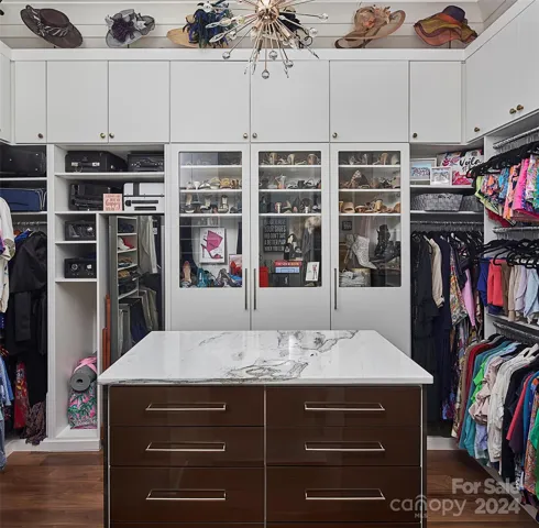 Boutique style closet in primary features lighted shoe closet and storage to 10'.