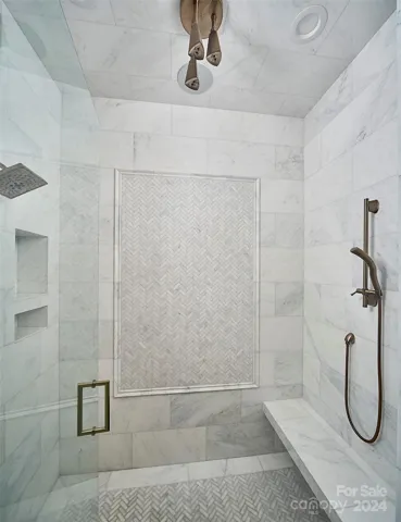 Zero entry shower with carerra marble floors, floating bench and 3 shower head options.
