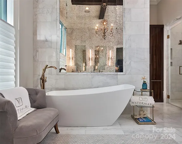 Striking feature wall of antique mirror surrounded by carrara marble sets the backroop for soaking tub.  Feels like vacation every day...