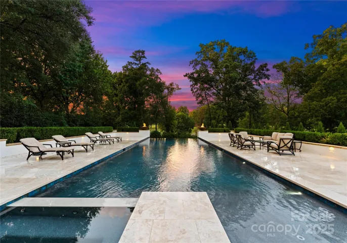 Oversized travertine pool deck with infinity edge pool