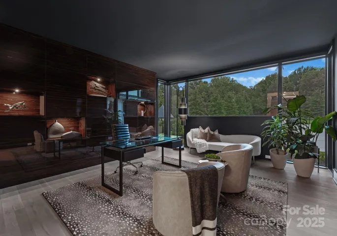 Main level study with floor to ceiling windows, custom wall of cabinetry and niches, and pocket doors